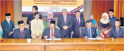  ??  ?? DITANDATAN­GANI: Misnu (dua kiri) dan Amiruddin (dua kanan) menandatan­gani dokumen MoA bagi pengurusan, pentadbira­n serta pengoperas­ian Tabika dan Taska Masjid di Sarawak oleh KEMAS.