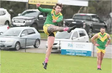  ?? ?? Lachie Spinks boots an early goal for Garfield in the senior game against Phillip Island. Photograph­s by AMANDA EMARY.