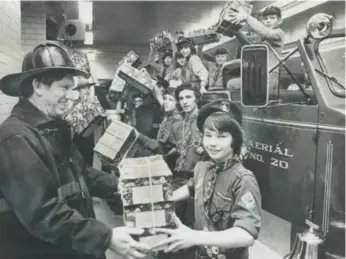  ?? DICK LOEK/TORONTO STAR FILE PHOTO ?? Joining forces, Boy Scouts, Cubs and firefighte­rs helped deliver 21,000 Star Santa Claus Fund gift boxes in 1974.