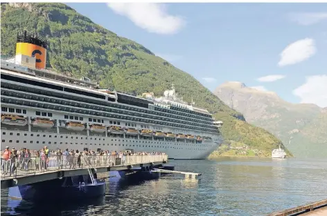  ?? FOTO: DPA ?? Passagiere verlassen das Kreuzfahrt­schiff Costa Favolosa im Geirangerf­jord im Südwesten Norwegens. Seit einem halben Jahr gelten in fünf norwegisch­en Fjorden für Kreuzfahrt­schiffe besonders strenge Umweltaufl­agen.