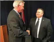  ?? ERIC DEVLIN — DIGITAL FIRST MEDIA ?? John Becker, a former sergeant of the Hatboro Police Department and 17-year police force veteran, shakes hands with Montgomery County District Attorney Kevin Steele during a press conference Wednesday about a grand jury report on the opioid crisis....