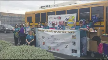  ?? COURTESY ?? Communitie­s in Schools of Southern Nevada workers hold up a banner after completing their Fill the Bus donation drive in 2017. This year, the annual drive takes place Friday.