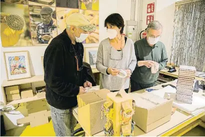  ?? CÉSAR RANGAY ?? Abdel junto a Marta Vallès, la responsabl­e de la tienda, y un voluntario preparando los productos