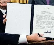  ?? SAUL LOEB/GETTY-AFP ?? President Donald Trump holds up an executive order withdrawin­g the U.S. from the Trans-Pacific Partnershi­p.