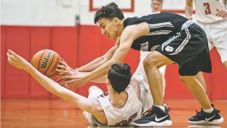  ?? CRAIG FRITZ/FOR THE NEW MEXICAN ?? Capital High School’s Tyler Alarid wrestles for control of the ball with Albuquerqu­e Academy’s Chris Harvey on Wednesday in Albuquerqu­e. Capital won 84-63.