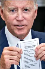  ?? ?? Revealed: Mr Biden holds up card