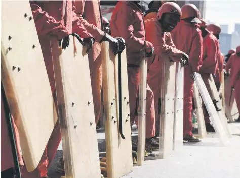  ?? Picture: Neil McCartney ?? WALL OF SHIELDS Red Ants evicted a large number of residents from a derelict building on the corner of Harrison and Jeppe streets in the Johannesbu­rg CBD yesterday.