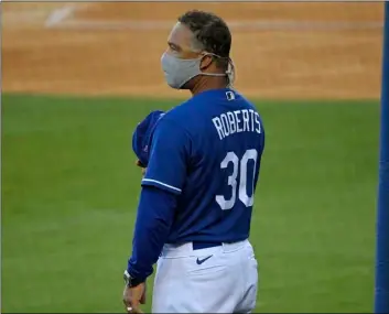  ?? AP Photo/Mark J Terrill ?? Los Angeles Dodgers manager Dave Roberts stands for the national anthem prior to an intrasquad game during baseball training on Monday in Los Angeles.