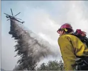  ?? Apu Gomes Getty Images ?? A HELICOPTER fights the Cave fire at Los Padres National Forest near Santa Barbara. The fire started Monday afternoon and prompted evacuation­s.