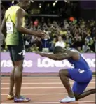  ?? MARTIN MEISSNER, THE ASSOCIATED PRESS ?? Gold-medal-winner Justin Gatlin kneels in front of Jamaica’s Usain Bolt after the 100-metre final in London on Saturday. Gatlin won gold with a time of 9.92 seconds. Bolt finished third.