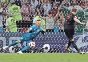  ??  ?? Croatia midfielder Ivan Rakitic scores his penalty past Russia goalkeeper Igor Akinfeev during their World Cup quarterfin­al. ADRIAN DENNIS/AFP/GETTY IMAGES