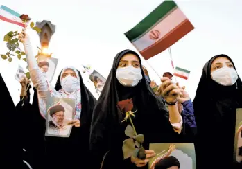  ?? EBRAHIM NOROOZI/AP ?? Supporters of Iranian president-elect Ebrahim Raisi celebrate after he won the presidenti­al election Saturday in Tehran, Iran. Many believe Raisi could be Iran’s next supreme leader when Ayatollah Khamenei, who is now 82, dies.