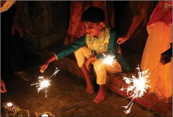  ?? Arkansas Democrat-Gazette/FRANCISCA JONES ?? Karthik Thotakura holds out one of the sparklers lighting the night at a Diwali gathering in Little Rock on Nov. 6.