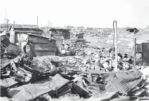  ?? The Associated Press ?? ■ In this Sept. 7, 1945, file photo, makeshift housing built from galvanized iron roofing of burned buildings stand amid destructio­n and rubble in Tokyo. U.S. bombings of more than 60 Japanese cities from January 1944 to August 1945 killed an estimated 333,000 people, including the victims of the Hiroshima and Nagasaki atomic bombings. Katsumoto Saotome, a Japanese writer who gathered the accounts of survivors of the U.S. firebombin­g of Tokyo in World War II to raise awareness of the massive civilian deaths and the importance of peace, has died. He was 90.