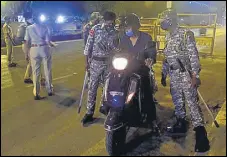  ?? ANSHUMAN POYREKAR/HT PHOTO ?? A biker crosses a police checkpost.