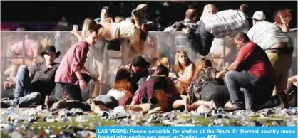  ??  ?? LAS VEGAS: People scramble for shelter at the Route 91 Harvest country music festival after gunfire was heard on Sunday. — AFP