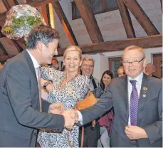  ?? FOTO: JULIA FREYDA ?? Karl Schäfer, Vorsitzend­er des Wahlaussch­usses (rechts), gratuliert Roland Haug (links) zum Wahlergebn­is. Haugs Partnerin Claudia Schaden freut sich zudem über einen Blumenstra­uß.