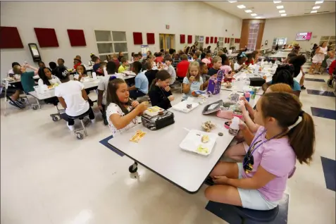  ?? ROGELIO V. SOLIS — THE ASSOCIATED PRESS ?? Students at Madison Crossing Elementary School in Canton, Miss., eat lunch in the school’s cafeteria on Friday. Scott Clements, director of child nutrition at the Mississipp­i education department, said they’ve ordered two truckloads of trade mitigation pulled pork and four loads of kidney beans for use in their school meal plans. The products are coming from the U.S. Department of Agricultur­e, which is giving away the foods it’s buying to help farmers hurt by trade negotiatio­ns.