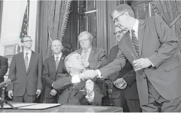  ?? Eric Gay / Associated Press ?? Gov. Greg Abbott, shakes hands with Lt. Gov. Dan Patrick, after signing SB 7. “Texas is going to impose real and stiff consequenc­es on any teachers who have any inappropri­ate relationsh­ip,” he said.