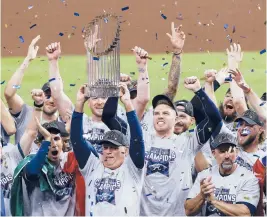  ?? GALVESTON COUNTY DAILY NEWS
KEVIN M. COX/THE ?? Braves manager Brian Snitker hoists the trophy as first baseman Freddie Freeman cheers after the Braves won the World Series over the Astros on Nov. 2 in Houston.