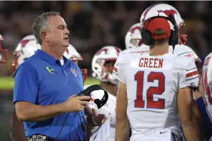  ?? Phelan M. Ebenhack/Associated Press ?? ■ SMU head coach Sonny Dykes, left, talks to his players Oct. 6, 2018, during a timeout in the first half of an NCAA football game against Central Florida in Orlando, Fla. Best to expect the unexpected in the AAC. The league has been fertile ground for fast turnaround­s since it rose from the ashes of the old Big East in 2013. SMU under second-year coach Dykes was in the thick of the West Division race last season until losing its last two. The Mustangs add former Texas quarterbac­k Shane Buechele, among several transfers who could give SMU more staying power.