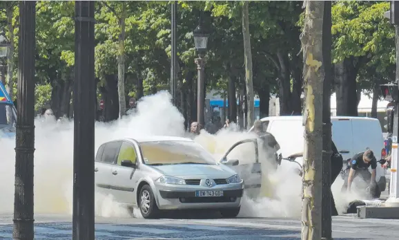  ?? Picture: AP ?? POINT OF IMPACT: French gendarmes use fire extinguish­ers after a man rammed into a police convoy and detonated an explosive device in Paris.