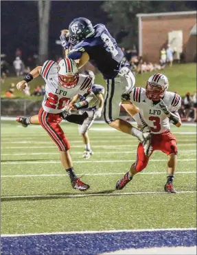  ??  ?? Colin Wright goes up and over LFO defensive backs Haydn Griffin and Sam Eaves to make a catch near the Warriors’ goal line. Gordon Lee scored 34 straight points in a 34-14 victory Friday night. (Photo by Greg Collins/CollinsPic­tures.com)