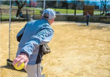  ?? KARL MERTON FERRON/STAFF PHOTOS ?? Larry Roberts winds back to pitch during softball practice at Centennial Park.