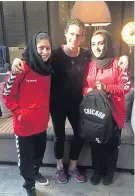  ??  ?? Support: Afghanista­n coach Kelly Lindsey with two of her players