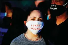  ?? The Associated Press ?? PROTESTING: Madeline Curry attends a protest with her father outside the Minneapoli­s 5th Police Precinct while wearing a protective mask that reads “I CAN’T BREATHE” on May 30 in Minneapoli­s. Protests continued following the death of George Floyd, who died after being restrained by Minneapoli­s police officers on Memorial Day.