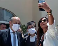  ?? AP ?? IT’S SELFIE TIME: A Lebanese woman takes a selfie with French Foreign Minister Jean-Yves Le Drian during his visit to the Carmel Saint Joseph school in Mechref district, Beirut, on Friday.—