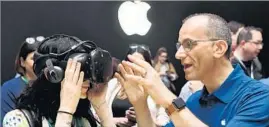  ?? Josh Edelson AFP/Getty Images ?? AN APPLE employee helps a woman try on an HTC Vive while testing out the iMac’s virtual reality capabiliti­es Monday at Apple’s developer conference.