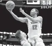  ?? Chris Carlson Associated Press ?? CAL STATE FULLERTON guard Landon Kirkwood shoots over UC Davis guard Stefan Gonzalez.