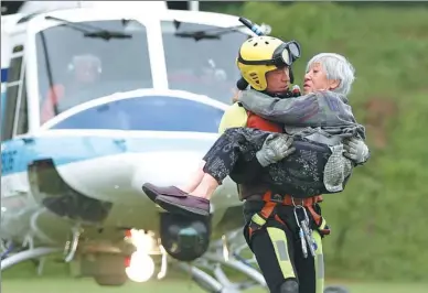  ?? KYODO VIA REUTERS ?? An elderly woman is carried away by a rescue worker on Friday in the flood-hit Japanese city of Asakura.