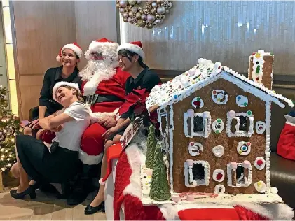  ?? PHOTOS: PAMELA WADE ?? Staff members on board the Silver Muse get friendly with Santa.