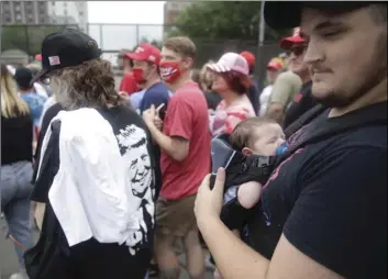  ?? MIKE SIMONS/TULSA WORLD VIA AP ?? Jacob Osborne and his son Phoenix, enter as safety barricade gates are opened for supporters to enter for President Donald Trump’s campaign rally on Saturday in Tulsa, Okla.