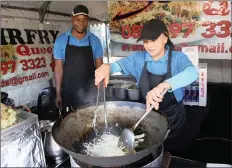  ??  ?? RIGHT: Queenie Pon andPrince Ndlova cook a Chinese feast at their stall.