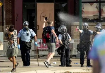  ?? Carlos Gonazales/Star Tribune via AP ?? Police pepper-spray protesters during a demonstrat­ion May 27 outside the Minneapoli­s Police Department’s 3rd Precinct building.