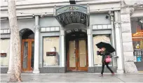  ??  ?? A downtown pedestrian walks past the old Bella Mia building.