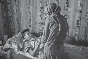  ?? TARA TODRAS-WHITEHILL/THE NEW YORK TIMES ?? Aziz, 13, who set himself on fire, is shown in May with his mother Olfa at home, where he is recovering from his burns, in Bou Hajla. In the cradle of the Arab Spring, the one country in the region with the best hope of realizing democracy and...