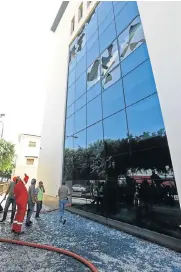  ?? Picture: AFP ?? ASSAULT AFTERMATH: Firefighte­rs and rescuers outside Libya's National Oil Company after armed men stormed the building