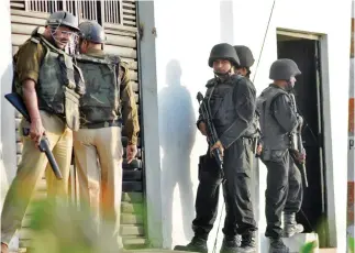  ??  ?? Anti Terrorist Squad (ATS) commandos and local police stand guard outside a house where a suspected militant was said to be hiding in Thakurganj area in Lucknow on Tuesday night.