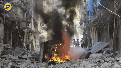  ?? PHOTO BY SYRIAN CIVIL DEFENSE WHITE HELMETS VIA AP ?? DESTRUCTIO­N: Syrians inspect damaged buildings after airstrikes by government helicopter­s on the rebel-held Aleppo neighborho­od of Mashhad, Syria, Tuesday.