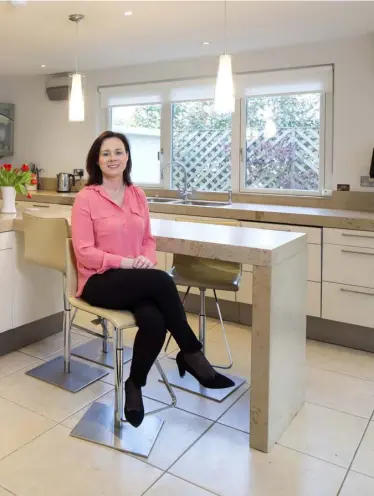  ??  ?? TOP LEFT: The dining area in Aisling O’Mahony’s house is floored in cream. The furniture is all from The Sofa Room in Leeson St Upper, D4
ABOVE: Dentist Aisling O’Mahony in her kitchen with its L-shaped island and limestone worktop. Aisling’s four...