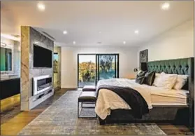  ??  ?? THE REIMAGINED three-bedroom contempora­ry home features backlit accent walls and a master suite with two closets.