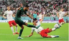  ?? Reuters ?? ■ Saudi Arabia’s Saleh Al Shehri skids to take the ball past Poland’s Jakub Kiwior at the Education City Stadium.