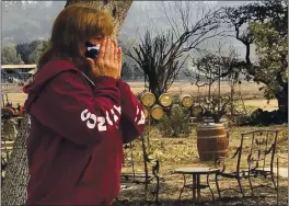  ?? HAVEN DALEY — THE ASSOCIATED PRESS ?? Nikki Conant cries as she looks at the debris of her home and business, “Conants Wine Barrel Creations,” after the Glass/Shady fire completely engulfed it, Wednesday in Santa Rosa.