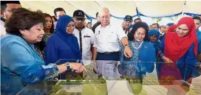  ?? — Bernama ?? Towards the future: Najib and Rosmah admiring a model of the Permata Kurnia project after officiatin­g its groundbrea­king ceremony in Bukit Katil.