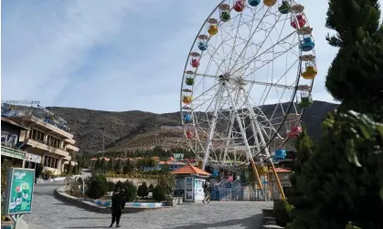  ?? Photograph: Wakil Kohsar/ AFP/Getty Images ?? Taliban guards standing watch next to an empty ferris wheel ride at the Zazai Park on the outskirts of Kabul.