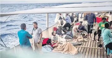  ?? — AFP photo ?? Migrants wait on board the NGO Proactiva Open Arms boat. A Spanish NGO said on June 30 it had rescued 59 migrants as they tried to cross the Mediterran­ean from Libya and would dock in Barcelona in Spain after Italy and Malta refused access. The news...